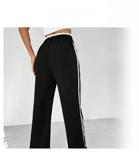 Vue détaillée du pantalon de sport noir avec taille élastique et rayures latérales blanches
