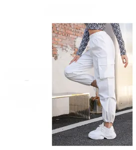 Détail d'un pantalon cargo blanc à taille haute avec poches à rabat et ourlets à cordon réglable