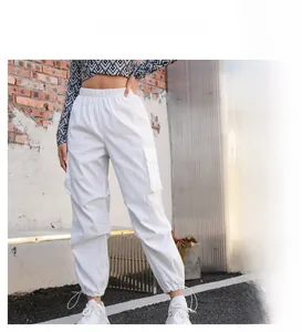 Détail d'un pantalon cargo taille haute avec poches à rabat et cordons de serrage