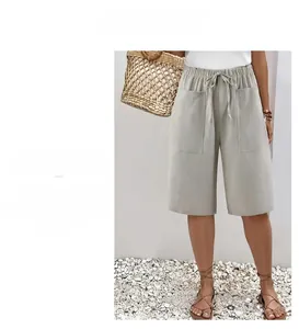 Detail of loose-fit summer shorts with elastic drawstring waist and large front pockets