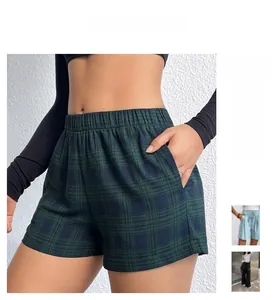 Dettaglio dei pantaloncini a quadri verde scuro con vita elastica e tasche laterali