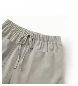 Detail of light gray casual shorts featuring elastic waistband, drawstrings and side pockets