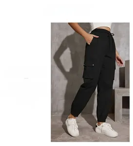 Detail of high-waist cargo pants featuring side flap pockets and adjustable drawstring waist