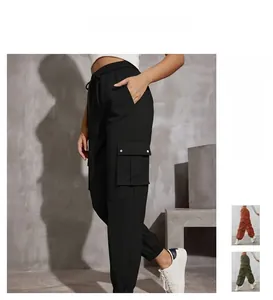 Detail of high waisted cargo pants with drawstring and functional metal buckle side pockets