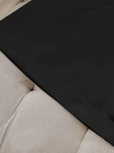 High-waisted black tailored shorts for women displayed on a beige tufted textured surface