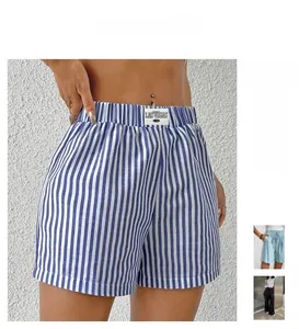 Detail of blue striped high-waisted shorts featuring an elastic waistband and woven logo tag