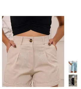 Detail of high waisted beige shorts featuring pleated waist and rolled hem design