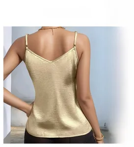 Detail of gold satin camisole featuring slim shoulder straps and low V-back design