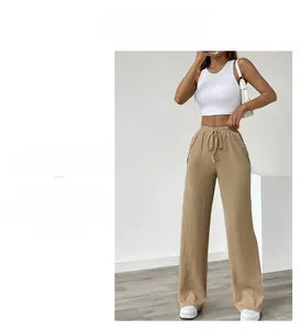 Detail of high waist wide leg trousers featuring waffle texture fabric and side buttons