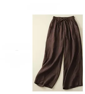 Detail view of brown wide-leg linen pants showing fabric texture and drawstring waist