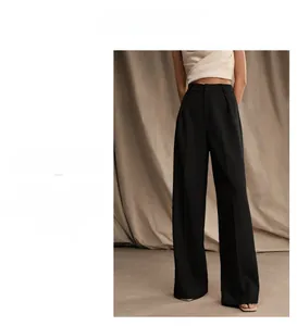 Detail of high-waist black wide-leg trousers with elegant drape and minimalist style