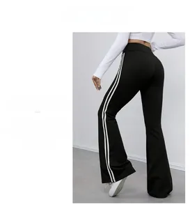 Détail du pantalon de yoga noir à taille haute avec doubles rayures et bas évasé tendance