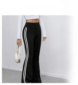 Détail du pantalon évasé noir à taille haute avec doubles bandes blanches et coupe élégante