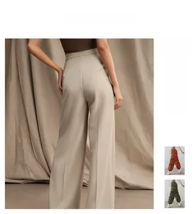 Detailed back view of high-waist beige wide-leg trousers showing drape and tailored fit