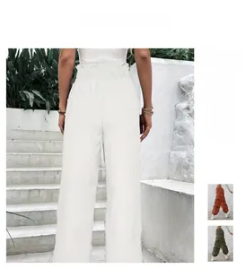 Detail of high waisted wide leg trousers with elastic ruffled waistband in white color