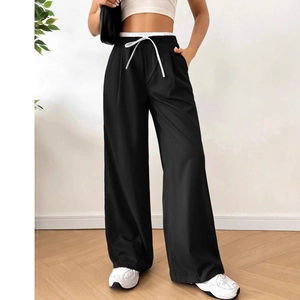 Detail of black straight-leg trousers with double-layered waist and white drawstring design