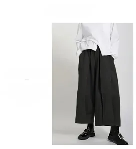 Detail view of high-waist wide-leg trousers with drape fabric and minimalist design