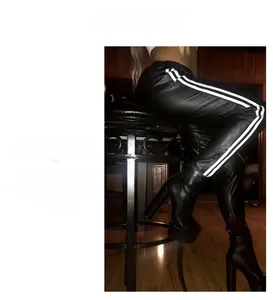 Detail view of plus size black faux leather pants with white side stripes and platform boots