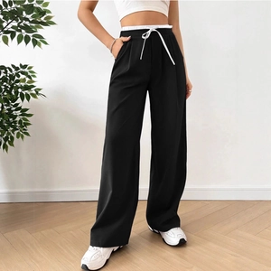 Detailed view of the high waist contrast white waistband and drawstring on black trousers