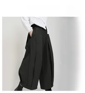 Detail view of high-waist wide-leg trousers showing brick red and olive green color options