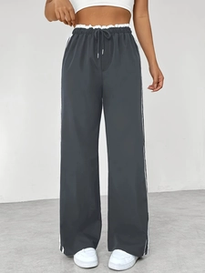 Pantaloni sportivi larghi grigio scuro da donna con strisce laterali bianche e coulisse
