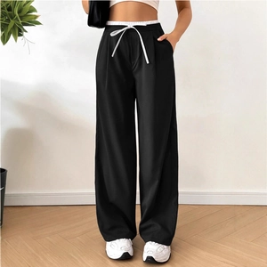 Detailed view of black high-waisted wide-leg trousers with white elastic drawstring waistband