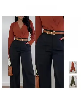 Close-up of black high-waisted wide-leg trousers with a brown metal buckle belt detail