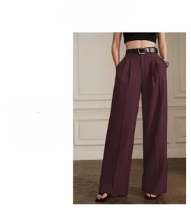 Detail of high waisted pleated wide leg trousers in deep purple with a black belt