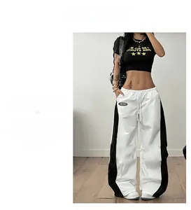 Detail der High-Waist Wide-Leg Sporthose mit seitlichen Kontrastbahnen und Logo