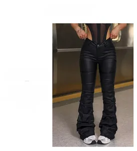 Detalle de pantalones negros de cuero PU de cintura alta con pliegues y corte acampanado