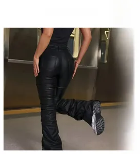 Detalle de los pantalones de cuero sintético negro acampanados con pliegues y efecto arrugado
