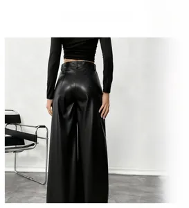 Detalle de pantalones de pernera ancha en cuero PU negro de cintura alta con caída