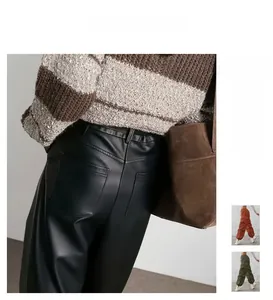 Détail du pantalon en similicuir noir à taille haute avec des poches et des plis chic