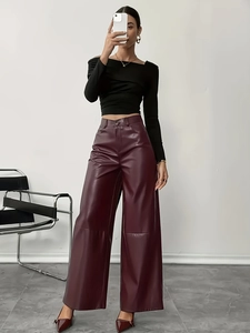 Pantaloni a gamba larga in pelle bordeaux da donna con top corto nero a maniche lunghe