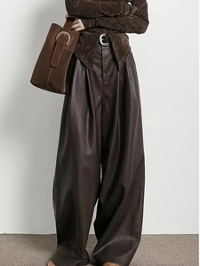 Détail du pantalon large en similicuir marron avec texture plissée et fini mat