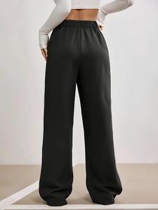 Back view of black high waist wide leg suit trousers with elastic waistband and drape