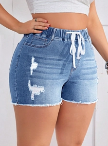 Dettaglio di pantaloncini di denim a vita alta con orli sfrangiati e coulisse bianca