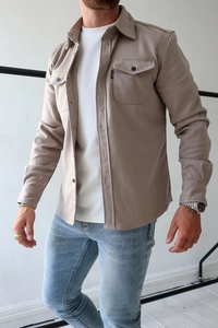 Detail of tan casual men's shirt featuring classic collar and flap pockets with woven labels