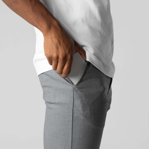 Slim portable power bank being placed into a gray casual trouser pocket for daily use
