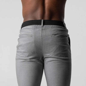Detail view of men's slim fit grey casual trousers with black elastic waistband and pockets