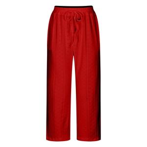Detailed close-up of red eyelet embroidery on cotton wide-leg drawstring trousers