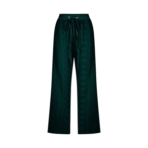 Detail of dark green wide-leg pants featuring drawstring waist and subtle textured fabric