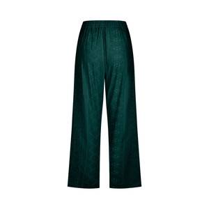 Detail of dark green wide-leg trousers showing elastic waist and textured fabric pattern