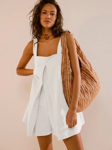 White square neck sleeveless romper with pleated detail and large striped woven bag
