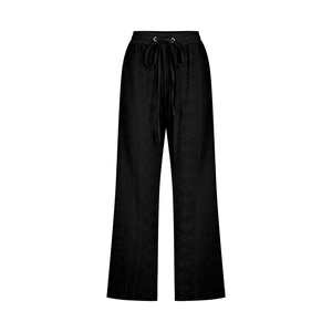 Detailed macro view of black wide-leg pants featuring textured fabric and drawstring waist