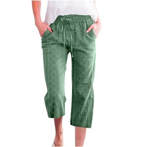 Detail of dark green cropped trousers with drawstring waist and geometric floral print