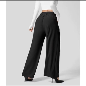 Dettaglio dei pantaloni a gamba larga a vita alta che mostrano il drappeggio fluido