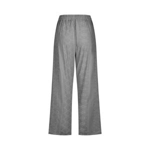 Detail of dark grey wide-leg trousers featuring elastic waistband and ethnic geometric pattern