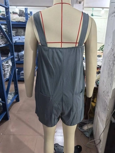 Detail view of grey summer playsuit back with dual pockets on a mannequin in a warehouse