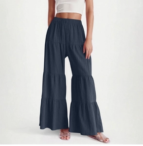 Detail of tiered wide-leg trousers showing the layered fabric and elastic high waist